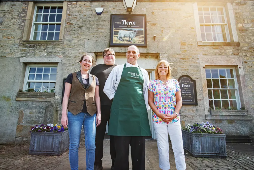 Members of the team stand out front of The Fleece Inn to celebrate their Countryside Alliance award win